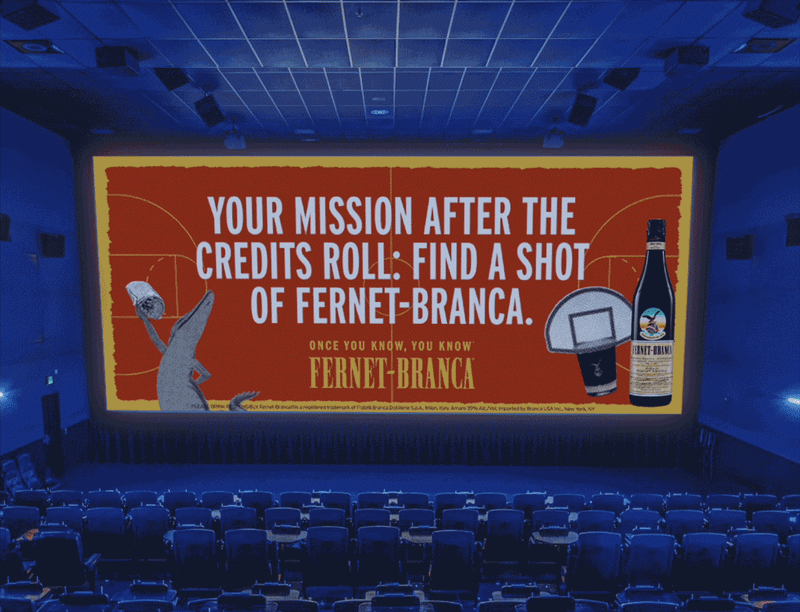 San Francisco cinema placement: theater screen reading 'Your mission after the credits roll: find a shot of Fernet-Branca.' with the 'Once you know, you know — Fernet-Branca' lockup, inside a blue-lit empty auditorium.